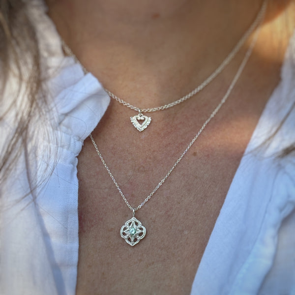Myth and Stone Heart in Bloom charm on neck with Compass of Light pendant