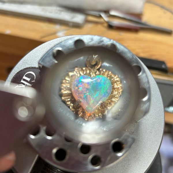 Myth and Stone Illuminated Heart opal charm under magnification