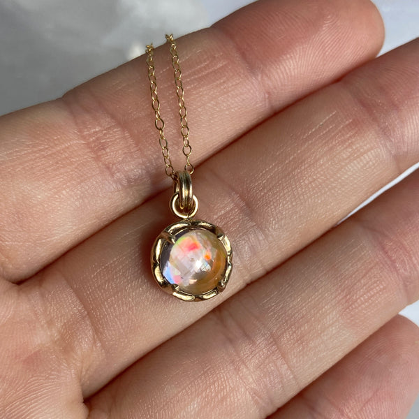 Myth and Stone Inner Light opal pendant in gold on hand